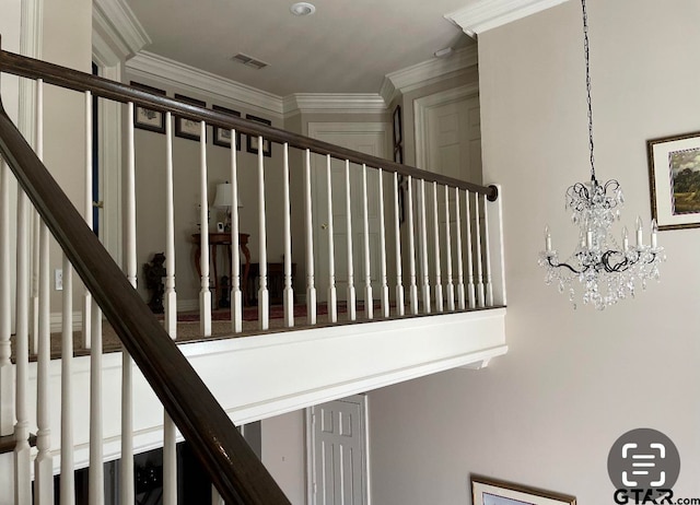 stairway featuring crown molding and a chandelier