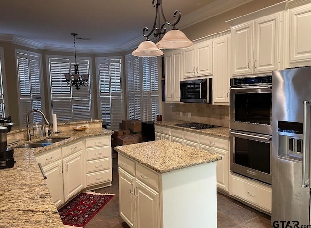 kitchen featuring appliances with stainless steel finishes, decorative light fixtures, an inviting chandelier, and sink