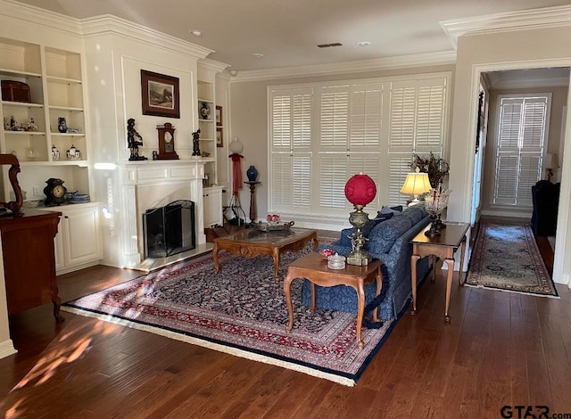 living area with dark hardwood / wood-style floors, built in features, and ornamental molding