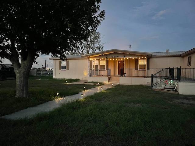 manufactured / mobile home with a lawn and a porch