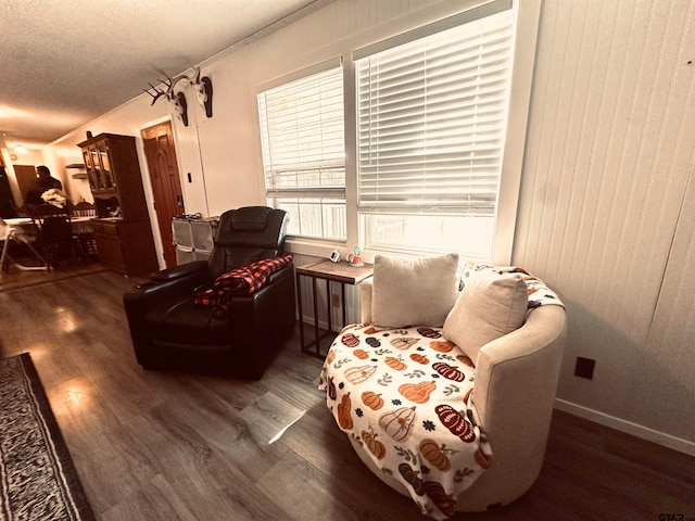 sitting room featuring a textured ceiling, dark hardwood / wood-style floors, and crown molding