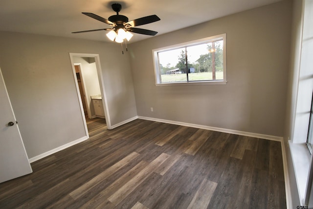 unfurnished bedroom with connected bathroom, ceiling fan, and dark hardwood / wood-style flooring