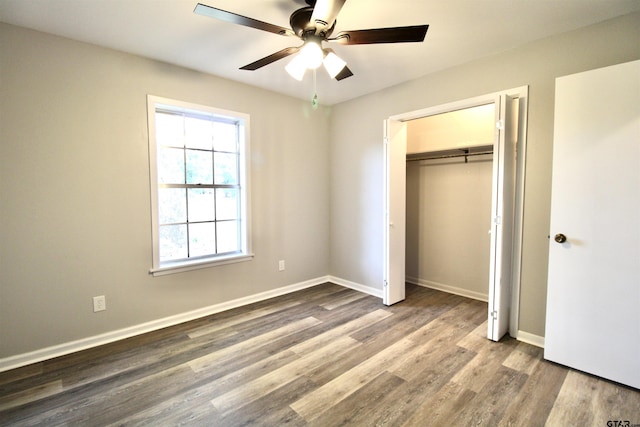 unfurnished bedroom featuring wood-type flooring, a closet, and ceiling fan