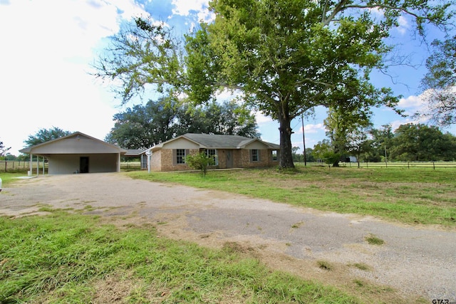 ranch-style home featuring a front lawn and a carport