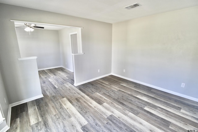 unfurnished room with ceiling fan and dark wood-type flooring