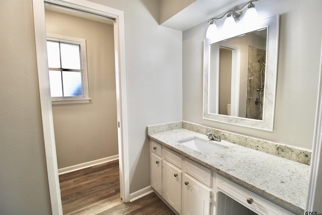 bathroom featuring wood-type flooring, vanity, and walk in shower