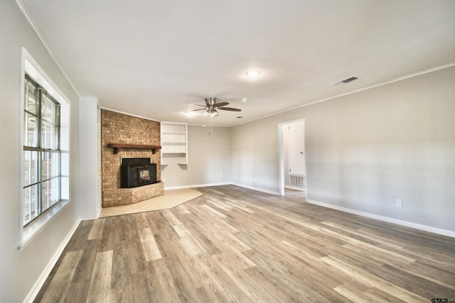 unfurnished living room featuring crown molding, built in features, and hardwood / wood-style flooring