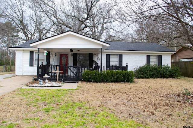 ranch-style house featuring a ceiling fan, covered porch, brick siding, and fence