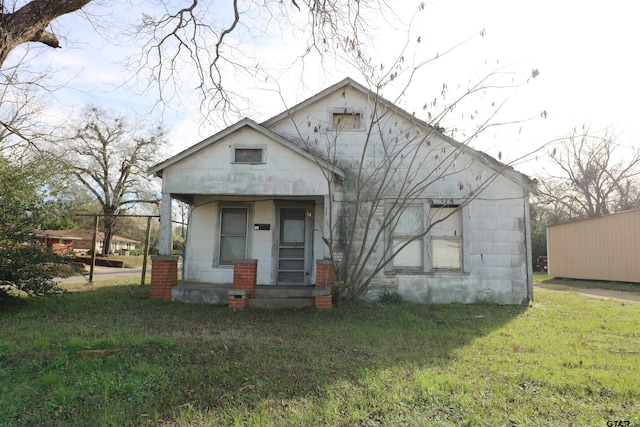 bungalow-style home with a front lawn