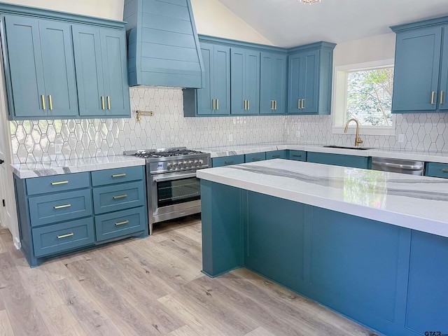 kitchen with stainless steel appliances, sink, custom exhaust hood, and light wood-type flooring