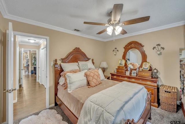 bedroom featuring ceiling fan, light hardwood / wood-style floors, and ornamental molding