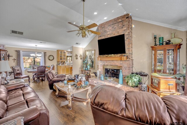 living room with ceiling fan with notable chandelier, crown molding, vaulted ceiling, hardwood / wood-style flooring, and a fireplace