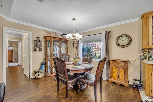 dining area featuring dark hardwood / wood-style flooring, an inviting chandelier, a textured ceiling, and ornamental molding