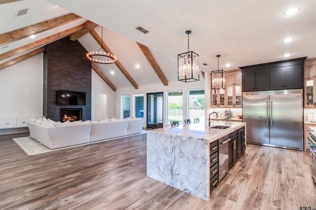 12240 Jazmin Cir, Flint, TX 75762 - kitchen featuring appliances with stainless steel finishes, a chandelier, beamed ceiling, recessed lighting, and light stone counters