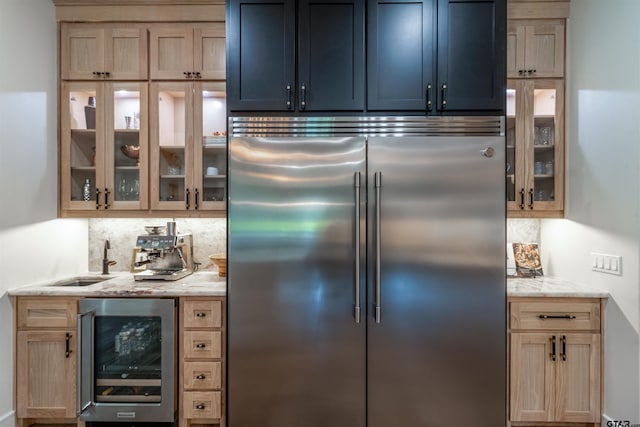12240 Jazmin Cir, Flint, TX 75762 - kitchen featuring stainless steel built in refrigerator, wine cooler, decorative backsplash, glass insert cabinets, and light stone counters