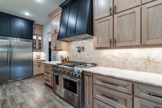12240 Jazmin Cir, Flint, TX 75762 - kitchen with high end appliances, custom range hood, wood finished floors, tasteful backsplash, and light stone countertops