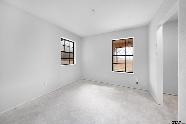 unfurnished room featuring concrete floors