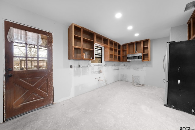 kitchen with concrete flooring, open shelves, appliances with stainless steel finishes, and glass insert cabinets