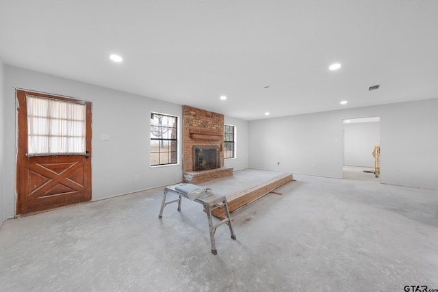 unfurnished living room featuring concrete floors, a fireplace, visible vents, and recessed lighting