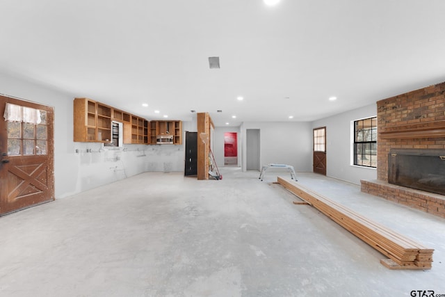 unfurnished living room with a fireplace, unfinished concrete flooring, and recessed lighting