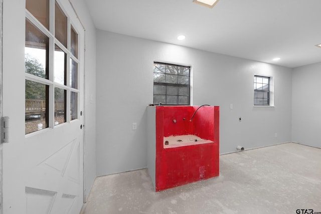 playroom featuring unfinished concrete flooring and recessed lighting