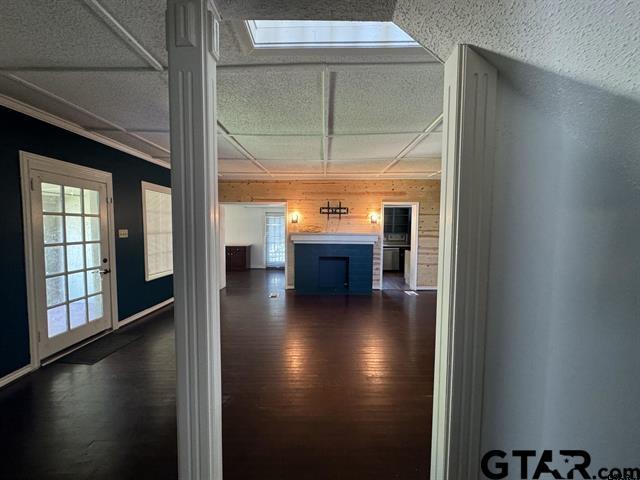 corridor with wood walls and dark hardwood / wood-style flooring