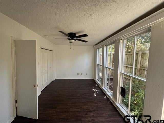 unfurnished sunroom with ceiling fan