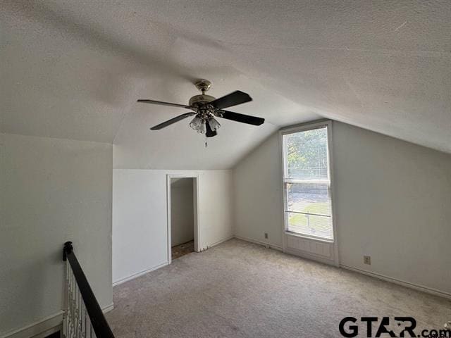 bonus room featuring a textured ceiling, light carpet, and lofted ceiling