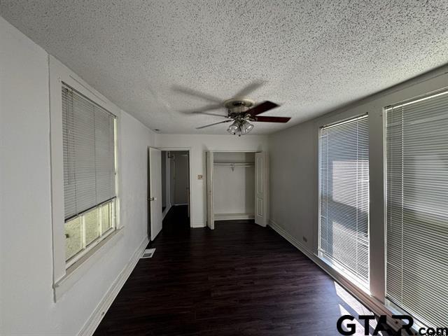 corridor featuring a textured ceiling and dark hardwood / wood-style floors