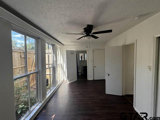 unfurnished sunroom with ceiling fan