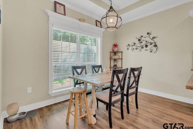 1216 Cobblestone Ct, Carthage, TX 75633 - dining area featuring healthy amount of natural light, a chandelier, wood finished floors, ornamental molding, and a raised ceiling