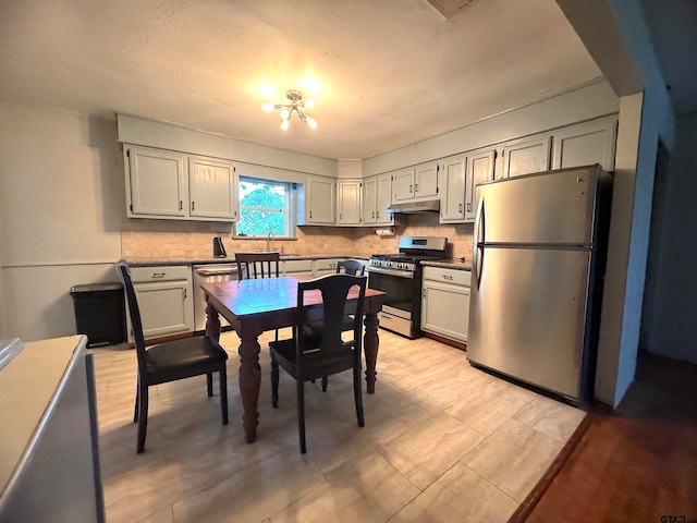 kitchen with stainless steel appliances, a chandelier, white cabinetry, and decorative backsplash