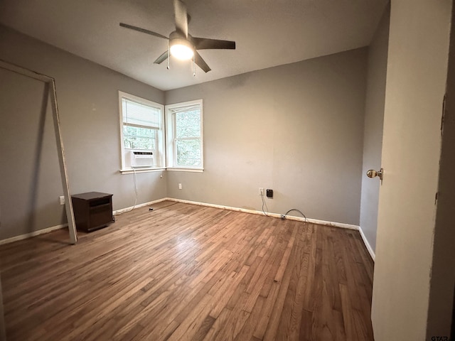 unfurnished bedroom with cooling unit, hardwood / wood-style flooring, and ceiling fan