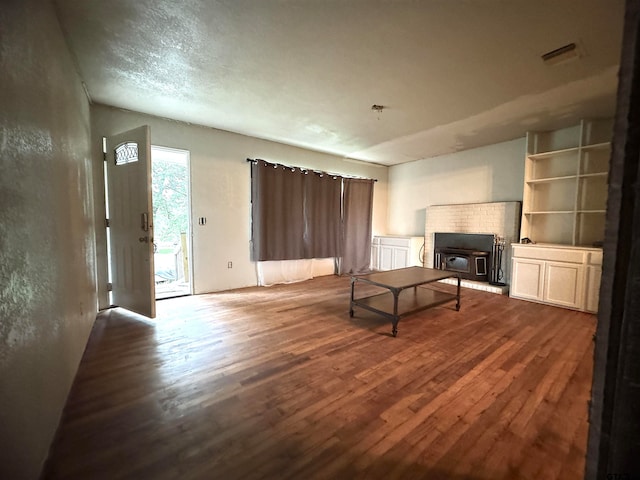 unfurnished living room featuring a wood stove and dark hardwood / wood-style flooring