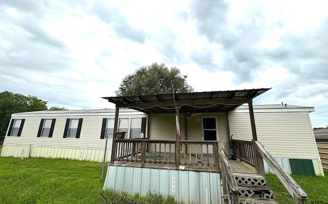 back of house with a wooden deck and a lawn