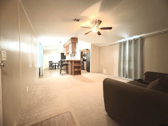 carpeted living room featuring ceiling fan and a textured ceiling