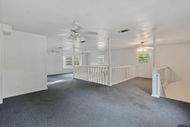spare room featuring carpet flooring, baseboards, visible vents, and ceiling fan