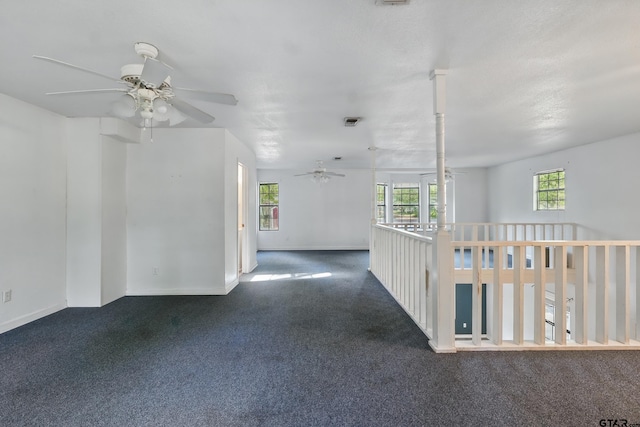 carpeted empty room with baseboards, visible vents, and ceiling fan