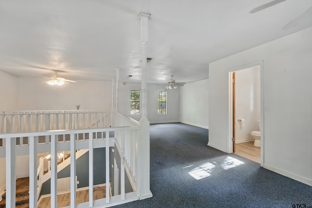 interior space featuring carpet flooring, a ceiling fan, and baseboards