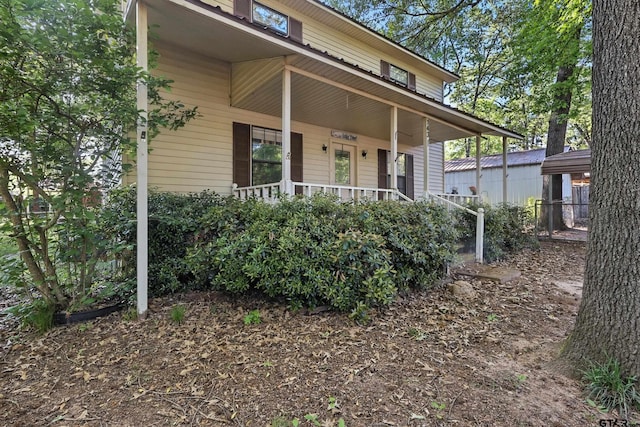 view of exterior entry featuring covered porch
