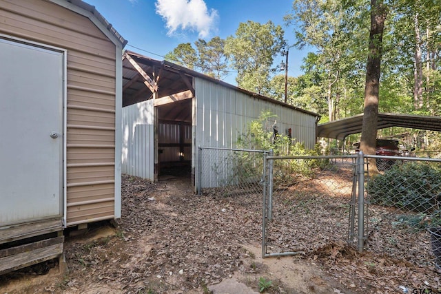 view of side of property with fence, an outbuilding, and a gate