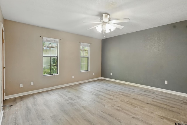 empty room featuring baseboards, a ceiling fan, and wood finished floors