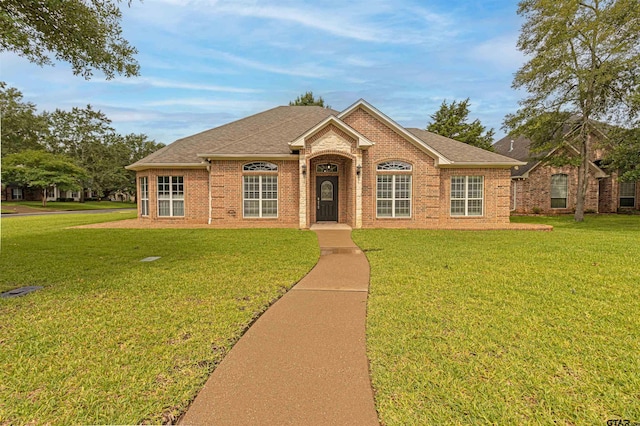 1868 Tall Timber Dr, Tyler, TX 75703 - view of front of house featuring brick siding, a front yard, and a shingled roof