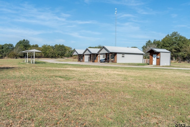 view of front of home featuring a front lawn and a storage shed