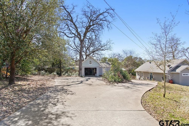 view of front of house with a garage, an outbuilding, and driveway