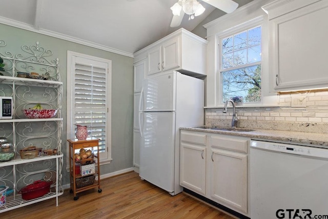 kitchen with light wood-style flooring, white appliances, a sink, white cabinets, and backsplash