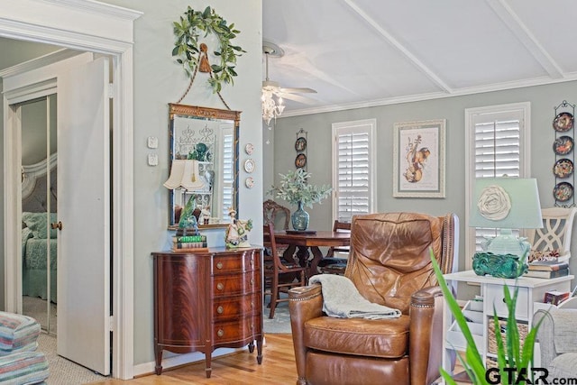 living area with crown molding, a ceiling fan, a wealth of natural light, and wood finished floors