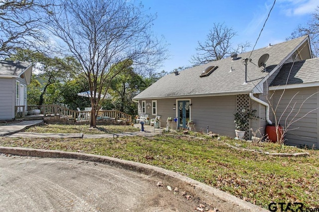 view of front of home featuring a shingled roof and french doors