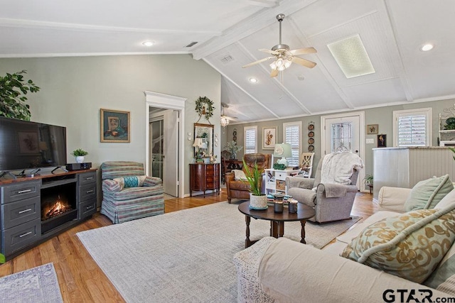 living area featuring light wood finished floors, a ceiling fan, lofted ceiling with beams, a fireplace, and recessed lighting