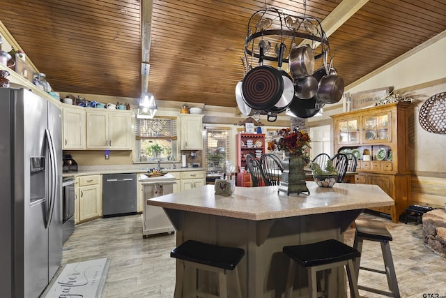 kitchen featuring a kitchen island, stainless steel appliances, vaulted ceiling, wooden ceiling, and a breakfast bar area